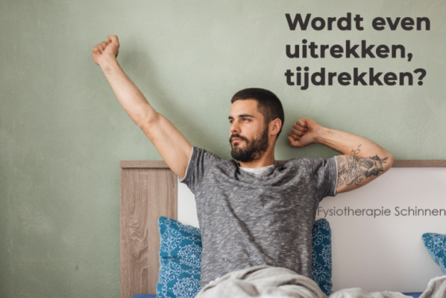 Man in een grijs shirt heeft last van stijfheid en rekt zich uit in bed.