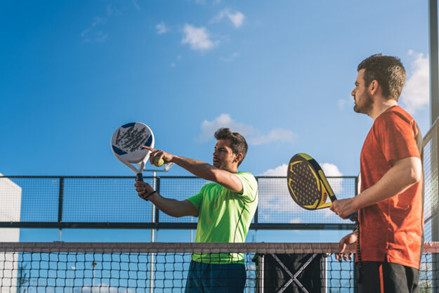 twee mannen zijn aan het padellen en krijgen last van een tenniselleboog