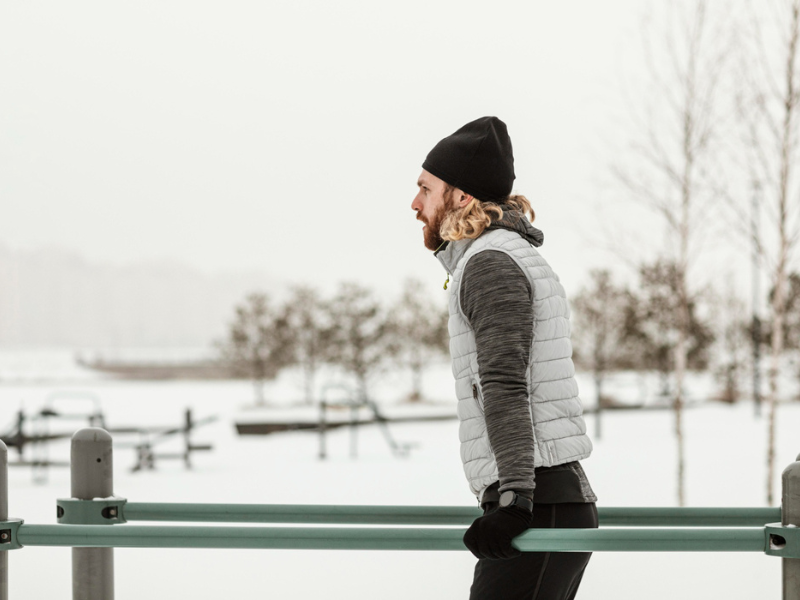 meneer is een warming up aan het doen buiten in de sneeuw